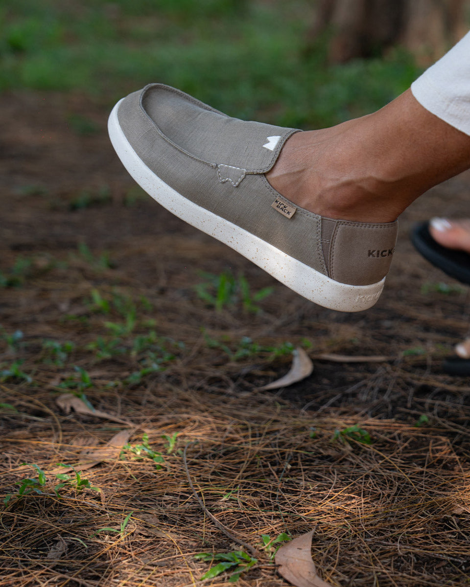 Brown shoe with white sole on a natural ground background